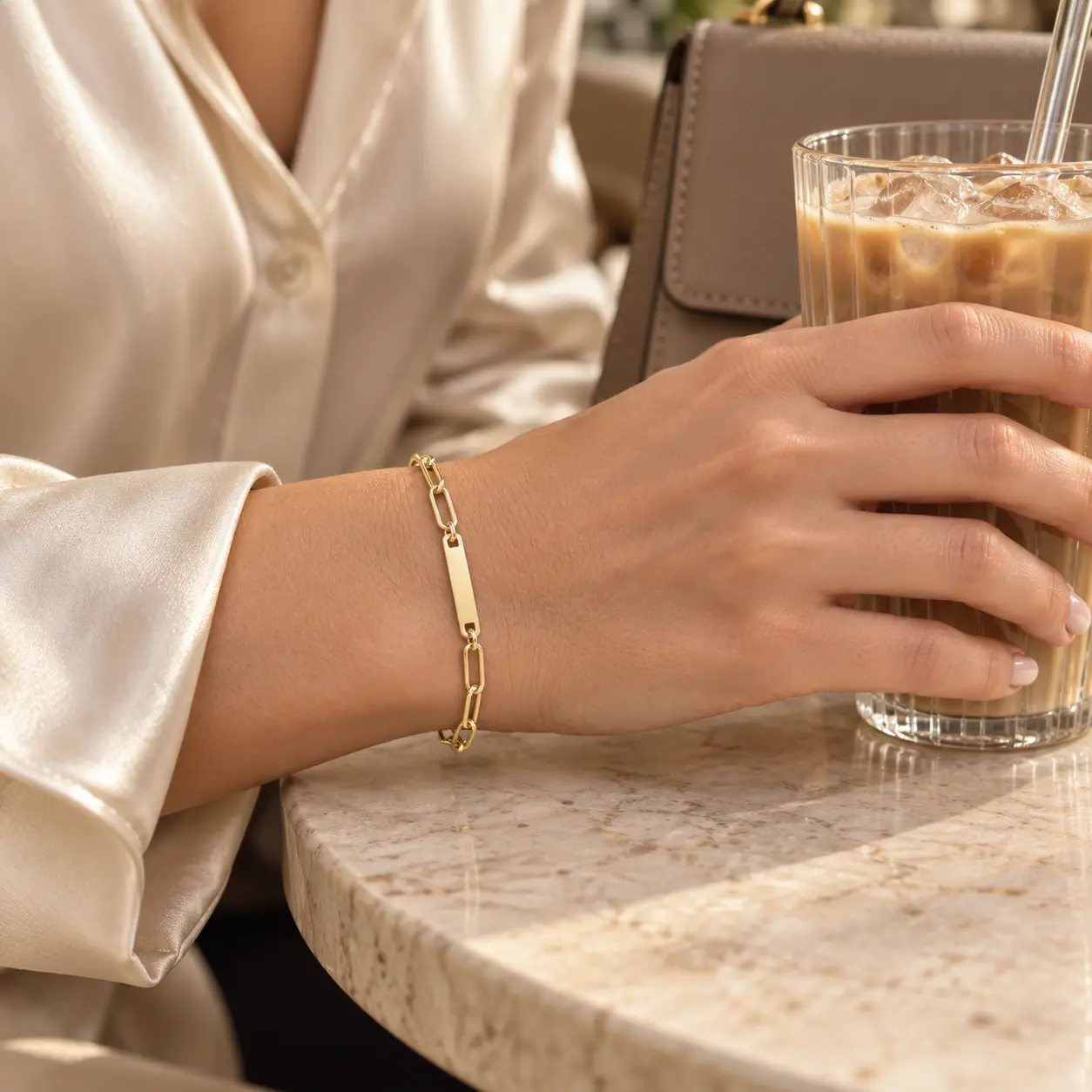 Gold Paperclip ID Bar Bracelet with an elongated link chain and slim rectangular engraving bar worn on the wrist
